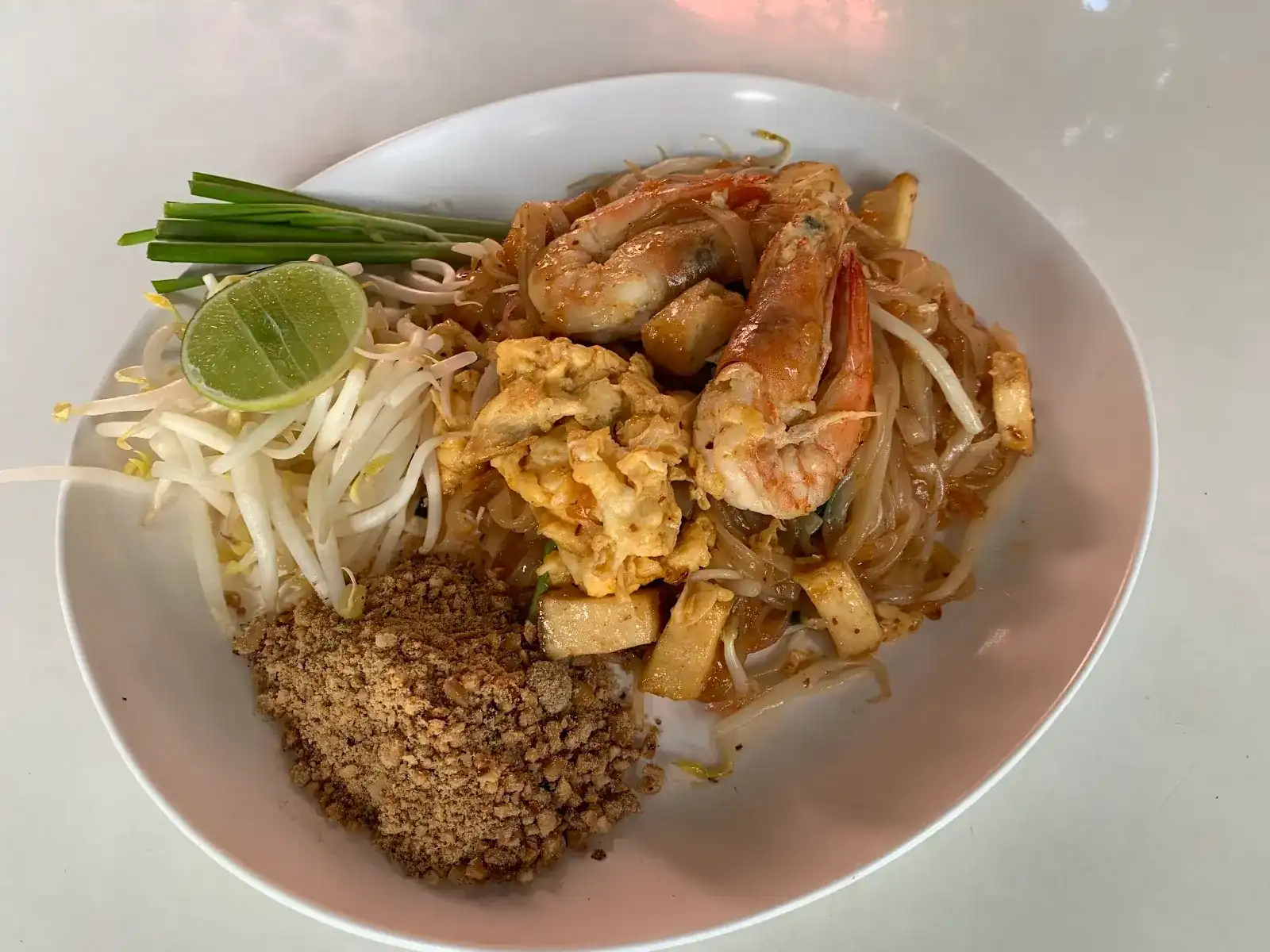 Pad thai with shrimp, egg and tofu, with bean sprouts, crushed peanuts, chives and lime
