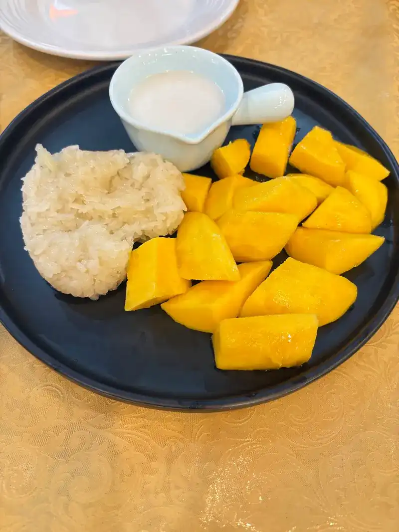 Ripe mango with sticky rice and a small jug of coconut cream