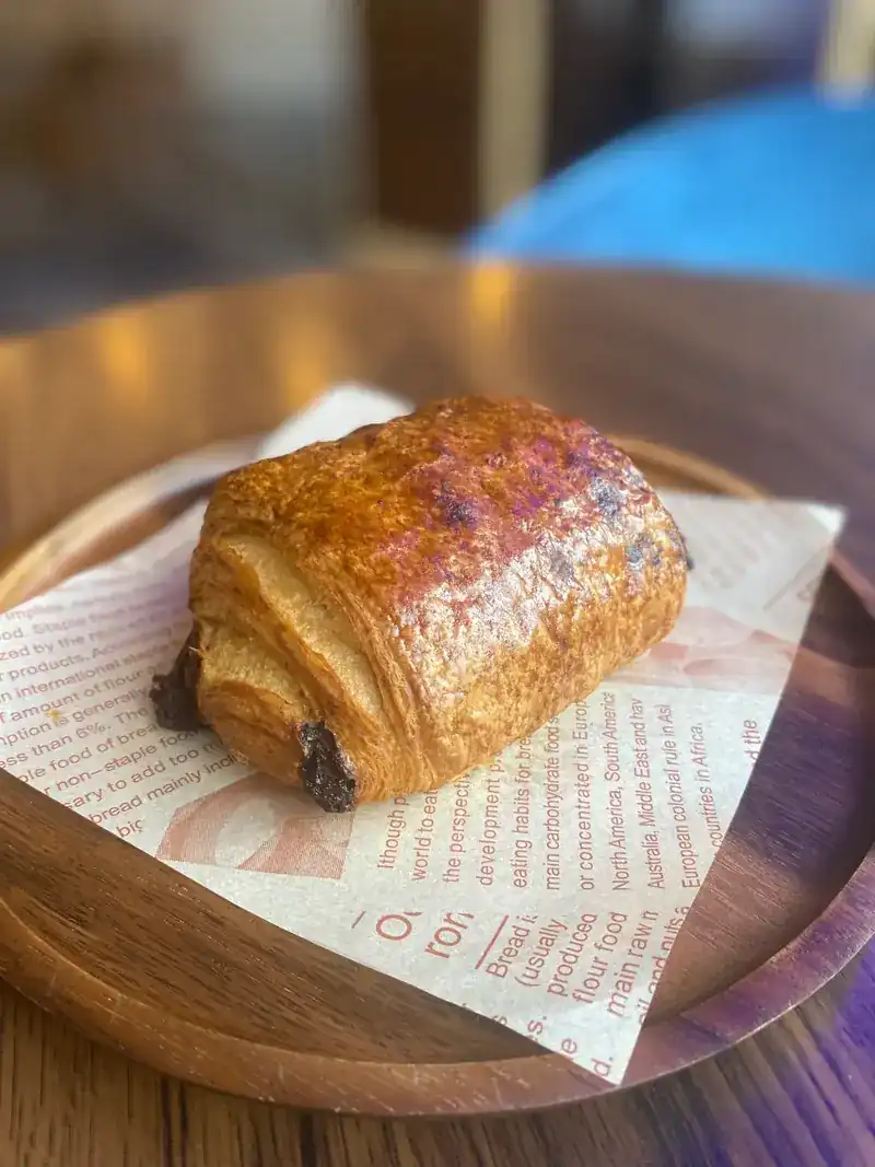 A pain au chocolat on a wooden plate