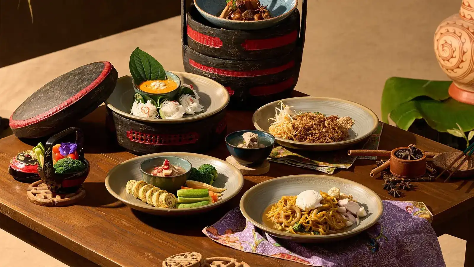 Royal Thai dishes served from a lacquered tiffin carrier on a wooden table