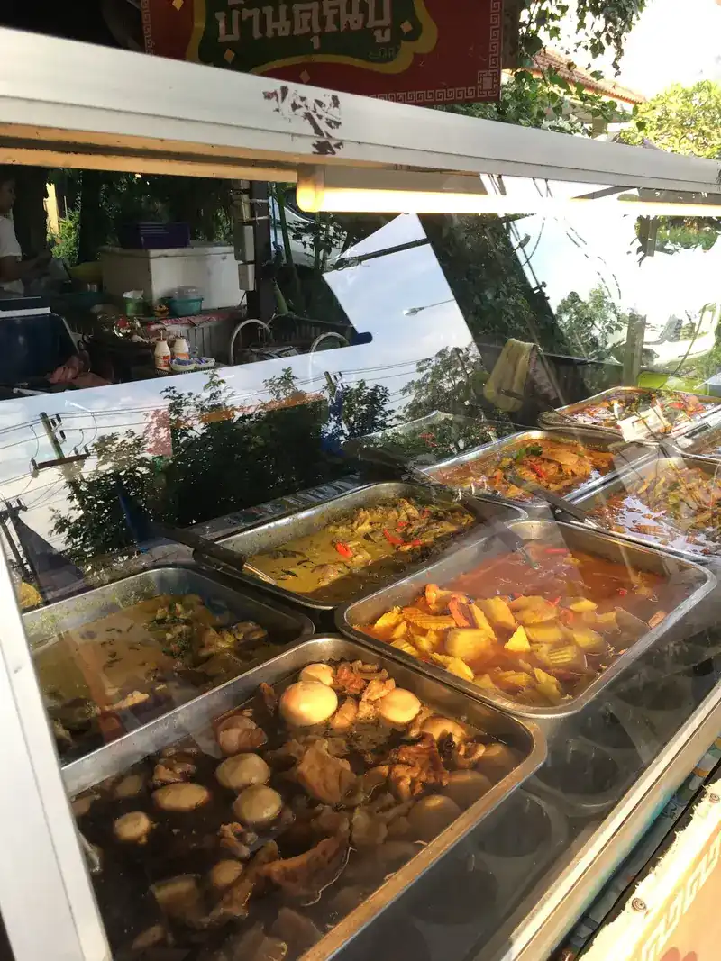 Trays behind the glass, one with eggs in a dark stew