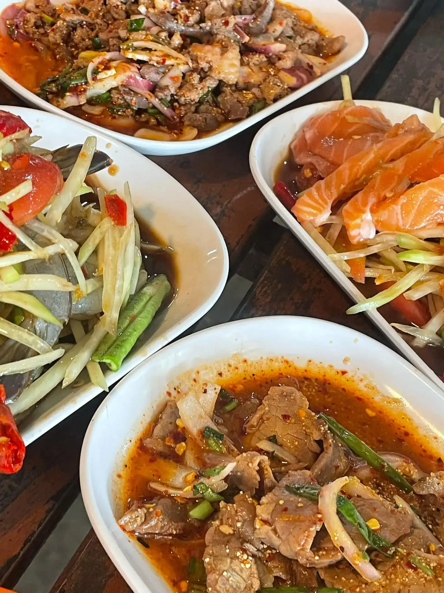 Laab, papaya salads with raw shrimp and with salmon, and spicy beef on one table / ลาบ ส้มตำกุ้งสด ตำแซลมอน และเนื้อรสจัด บนโต๊ะเดียวกัน