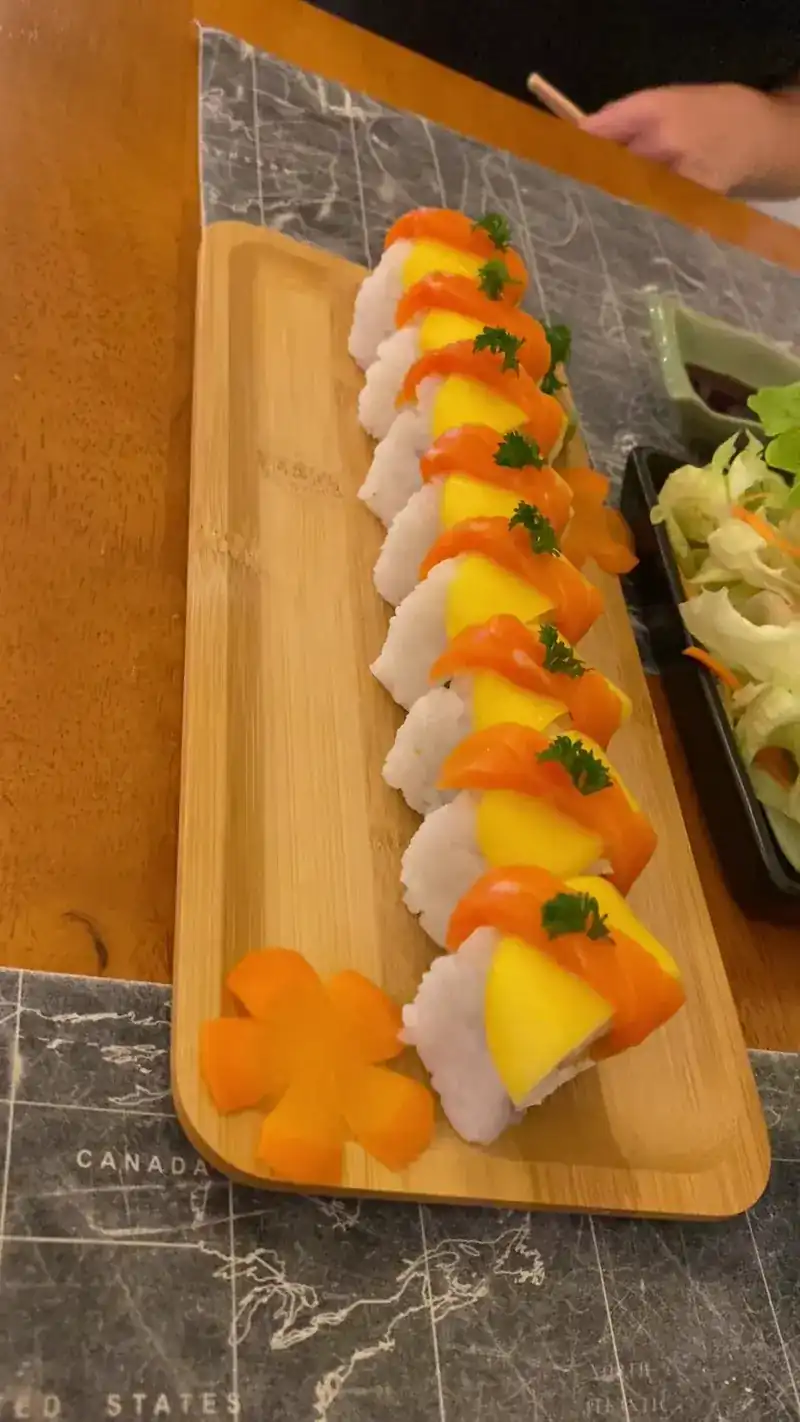 Salmon and mango roll on a long wooden plate