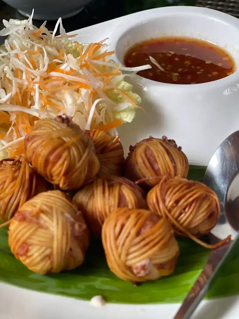 Deep-fried pork balls wrapped in noodles, with a dipping sauce