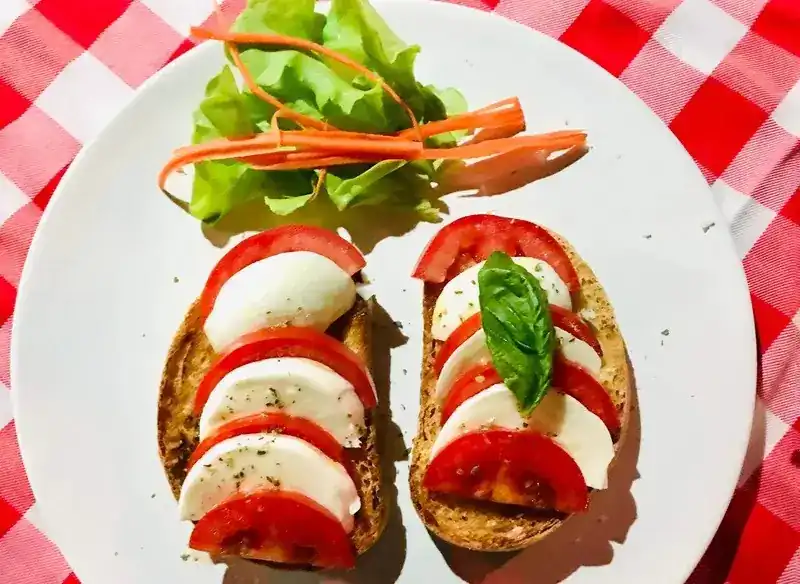 Two bruschette layered with mozzarella and tomato slices