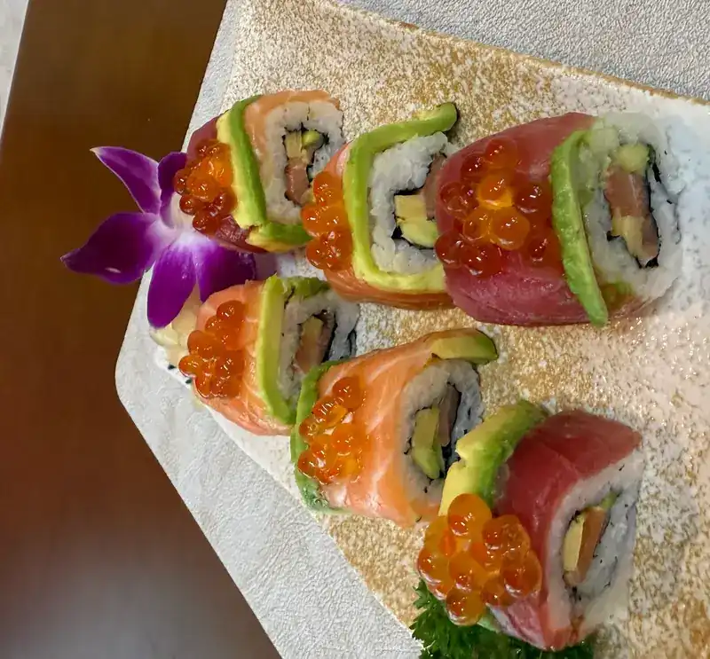 Rolls wrapped in salmon, tuna and avocado, topped with salmon roe
