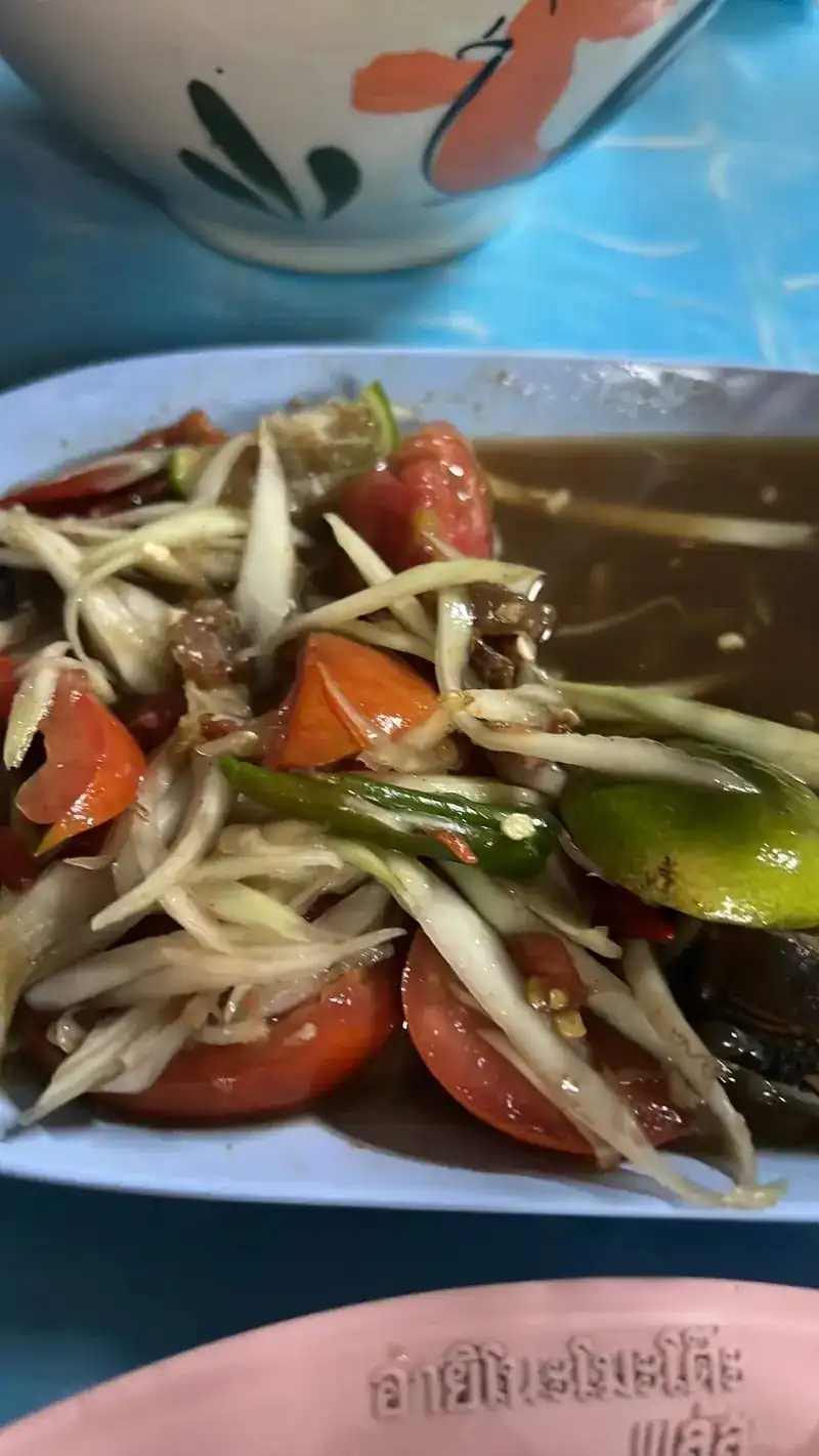 Close-up of papaya salad with tomato and lime