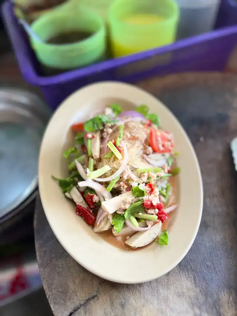 A tangy salad with tomato, onion, chilli and Chinese celery on an oval plate