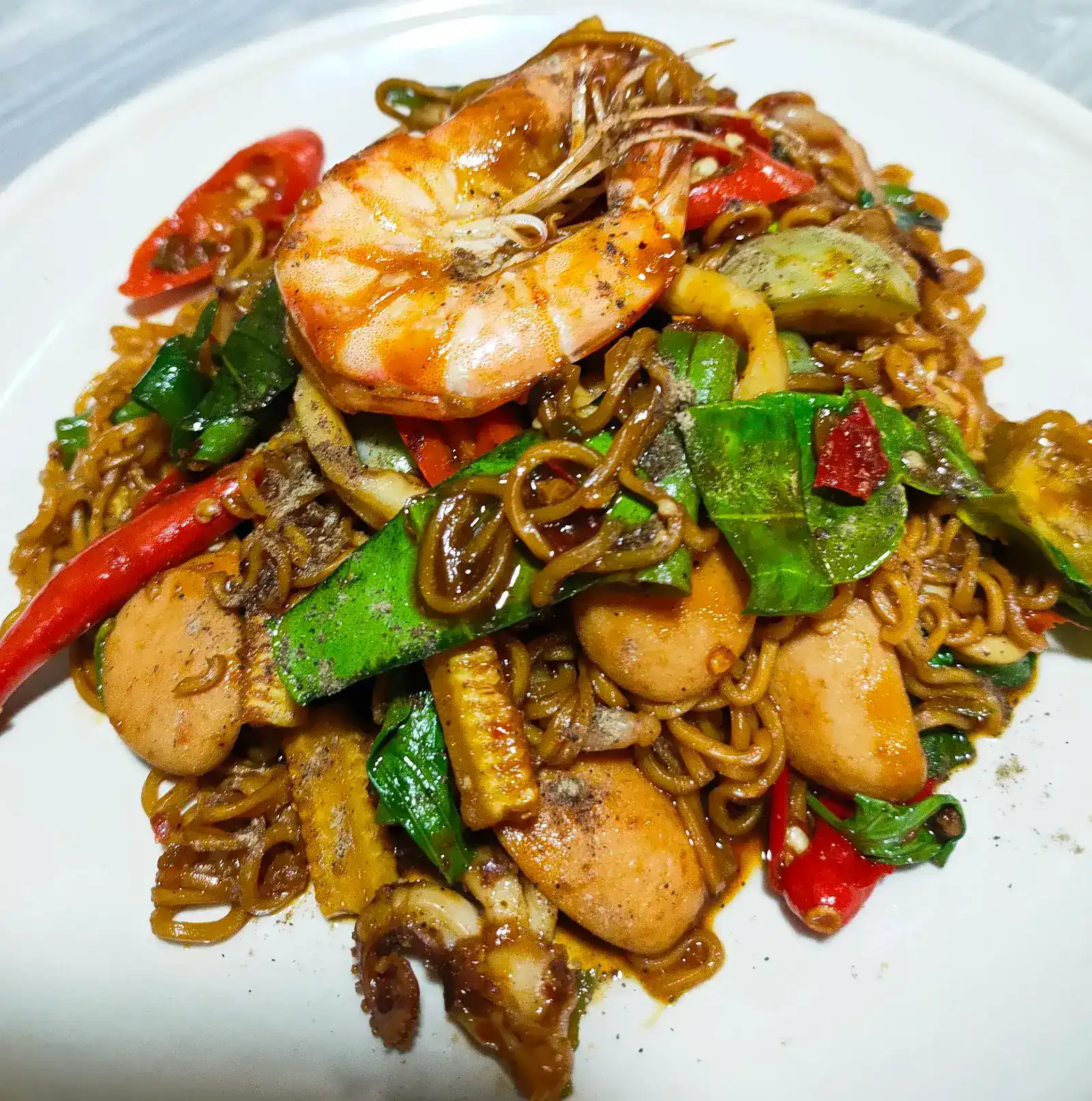 Stir-fried noodles with prawn, squid, sausage and fresh chilli