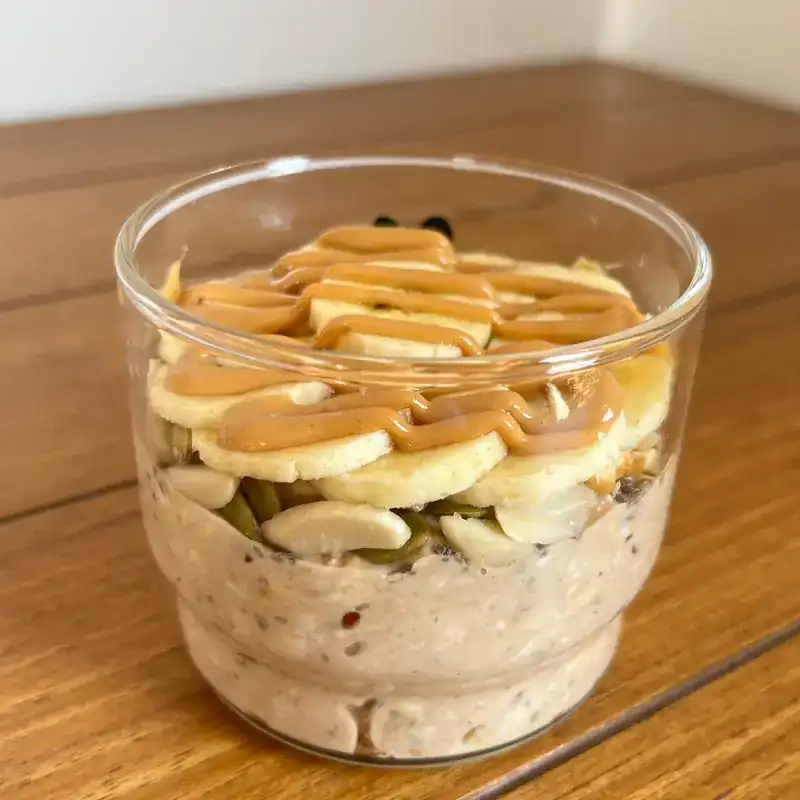 Overnight oats in a glass with banana, almonds and peanut butter