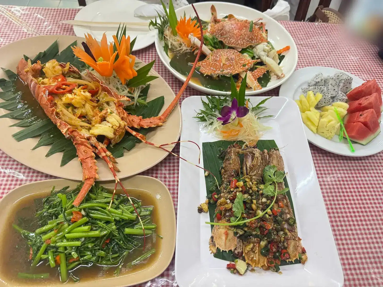 A table at Kwong Shop: lobster, blue crabs, mantis shrimp with chilli, stir-fried morning glory and a plate of fruit / โต๊ะอาหารที่ร้าน: ล็อบสเตอร์ ปูม้า กั้งโรยพริก ผักบุ้งผัด และผลไม้