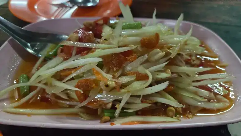 Papaya salad with long beans on a pink plate