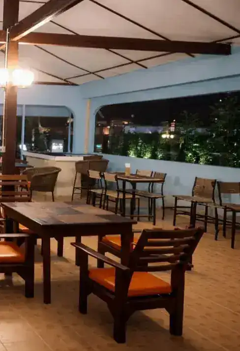 The dining room at night, tables set under the pavilion roof