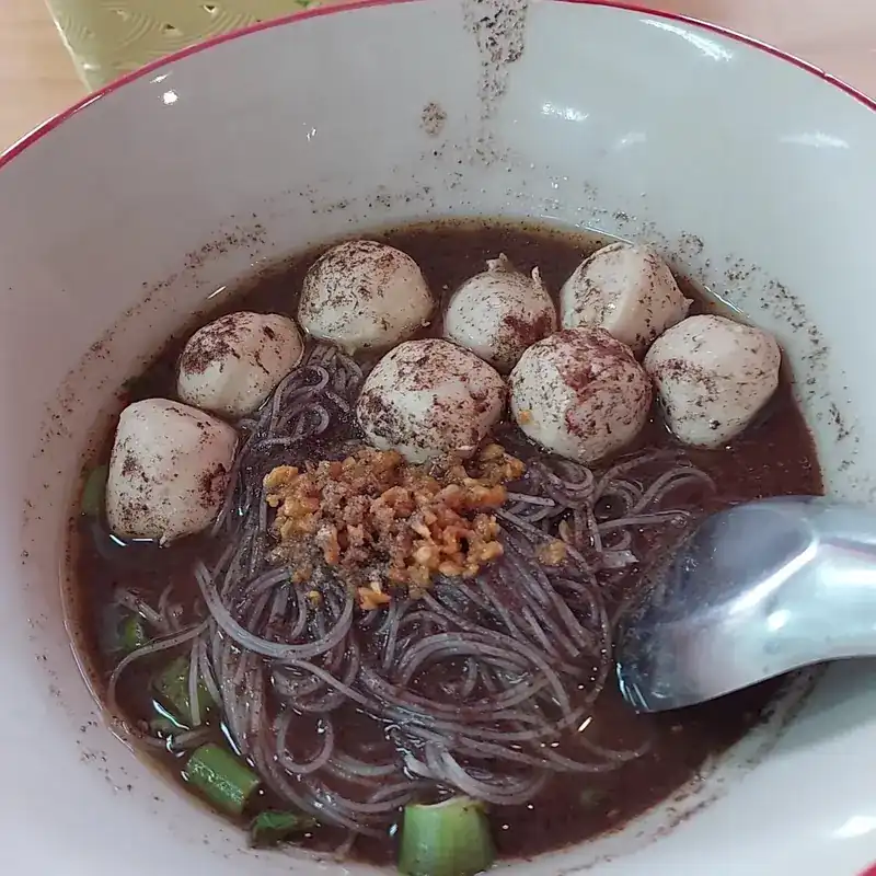 Boat noodles with meatballs and fried garlic over thin noodles