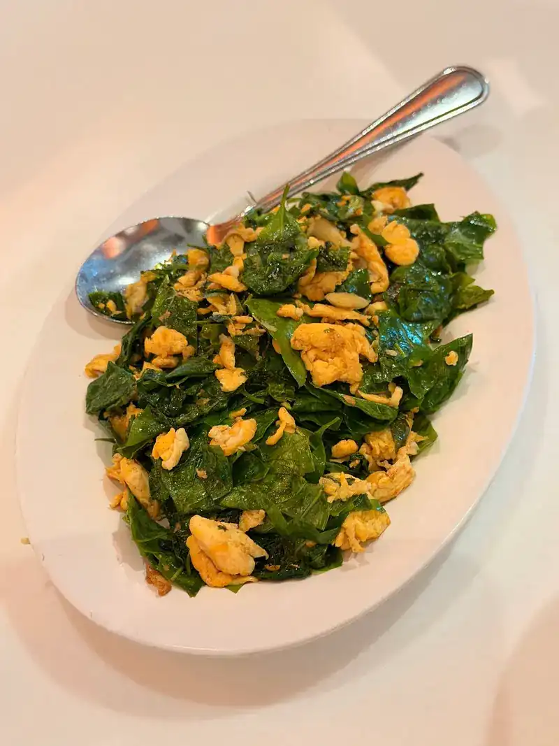 Dark leafy greens stir-fried with egg on an oval plate