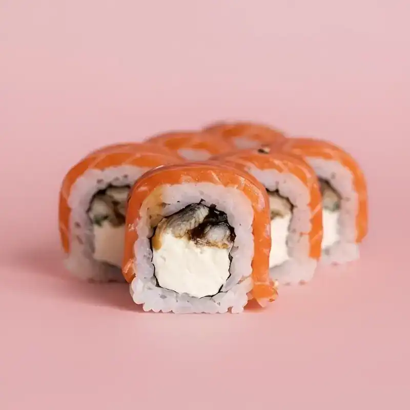 Salmon-wrapped roll with unagi and cream cheese on a pink background