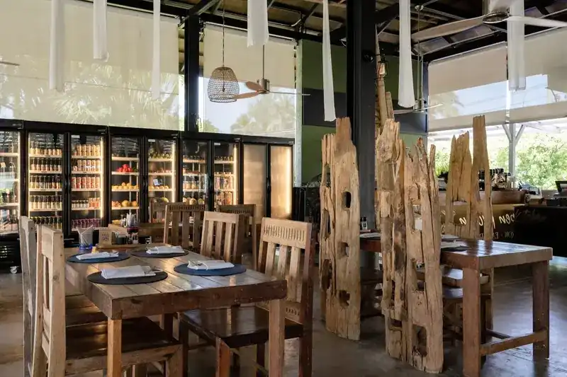 The open-sided dining room with timber tables and driftwood screens
