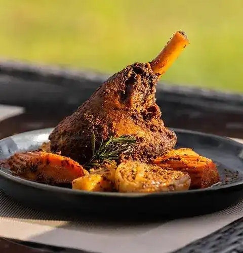 Lamb on the bone with roasted potatoes and a sprig of rosemary