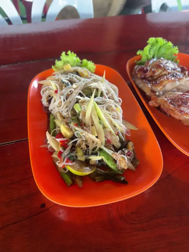 Som tam with noodles and long beans on an orange plate