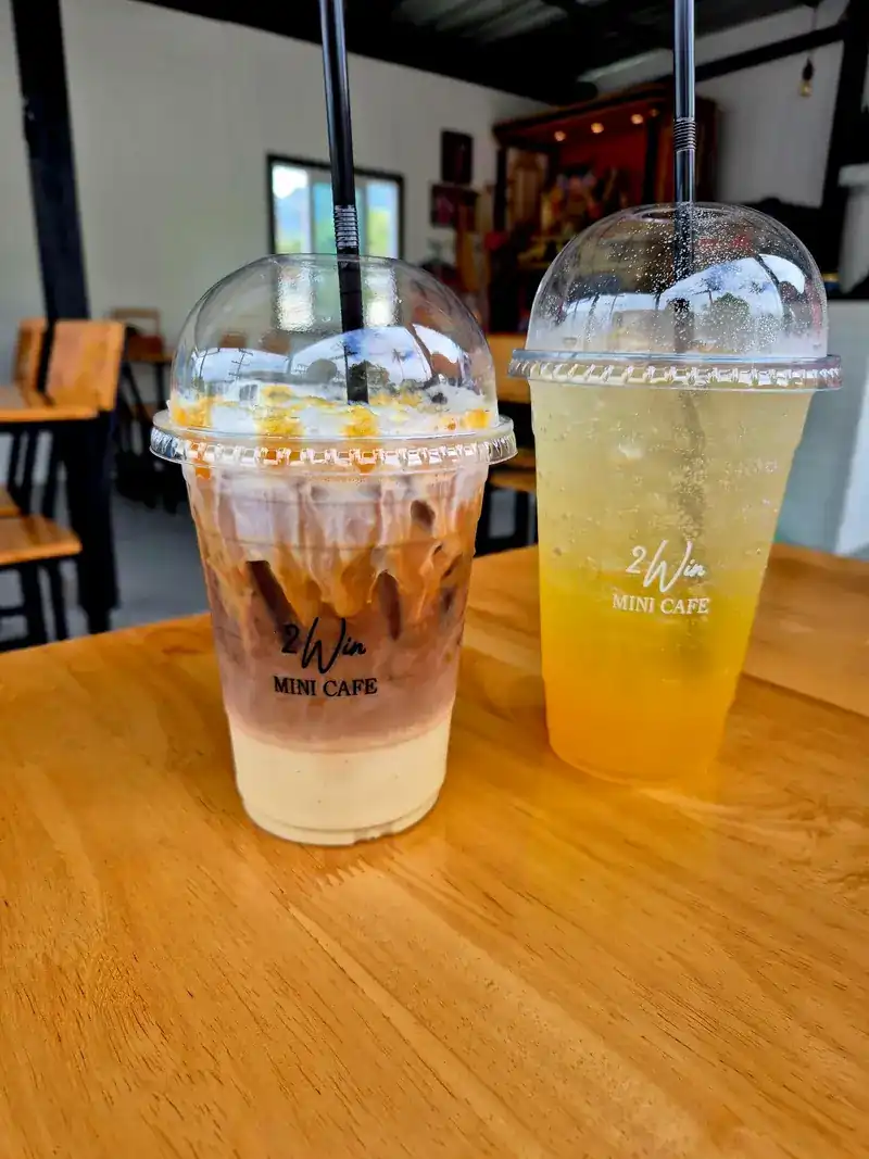 Two iced drinks in 2Win cups on a wooden table
