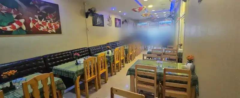 The long dining room with leather benches, wooden chairs and a koi painting on the wall