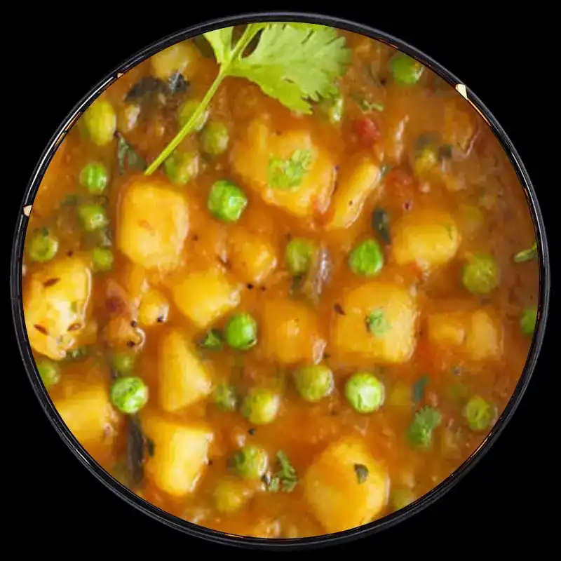 Potatoes and green peas in tomato gravy