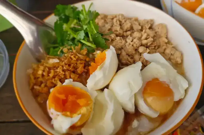 A bowl with soft-boiled eggs and coriander