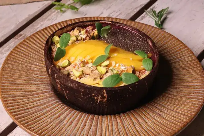 Açaí bowl with mango in a coconut shell