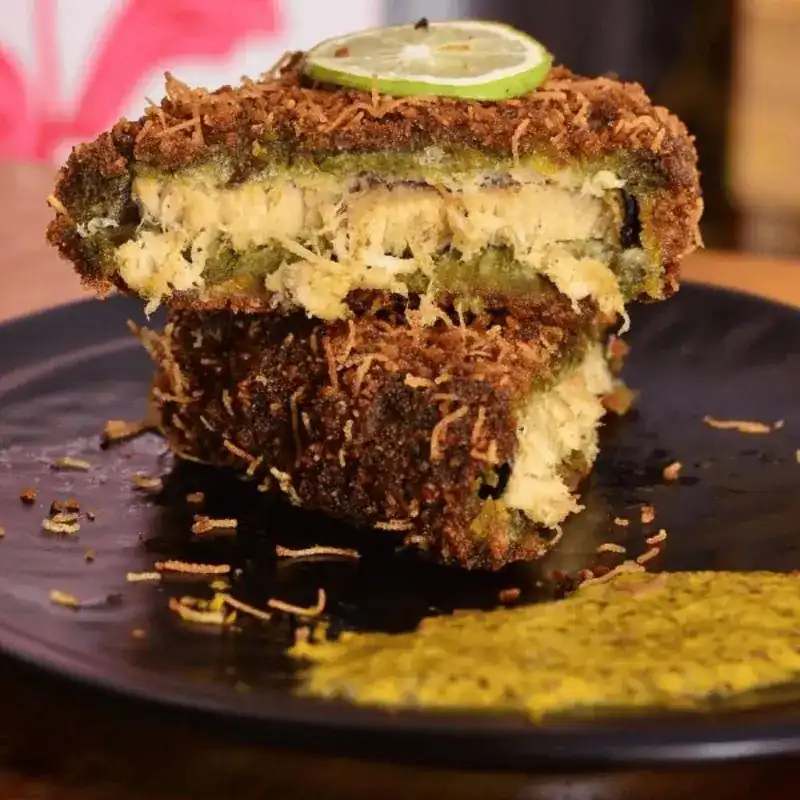 Crumbed vegan fish fry cut open, topped with a slice of lime