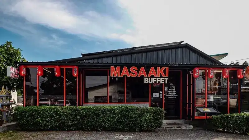 Masaaki from the road: a dark building with red window frames, red lanterns and the Masaaki Buffet sign
