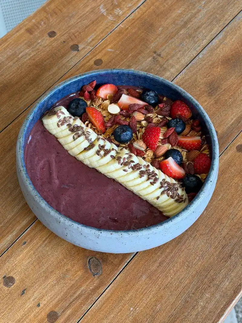 A smoothie bowl with banana, strawberries, blueberries and granola
