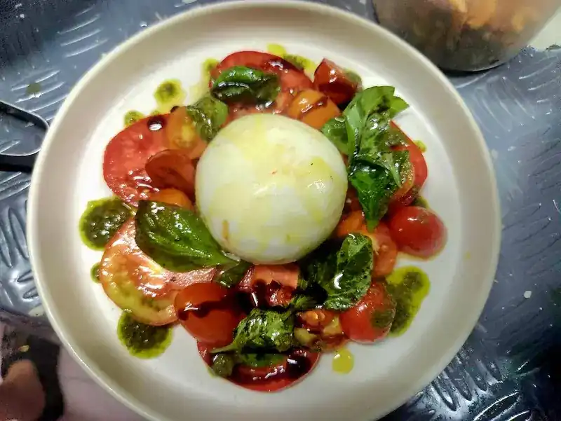 Burrata on sliced tomatoes with basil, pesto and balsamic
