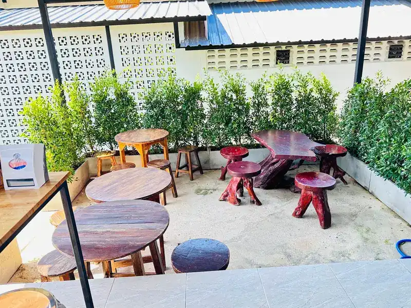 Garden seating with round wooden tables and red tree-trunk stools