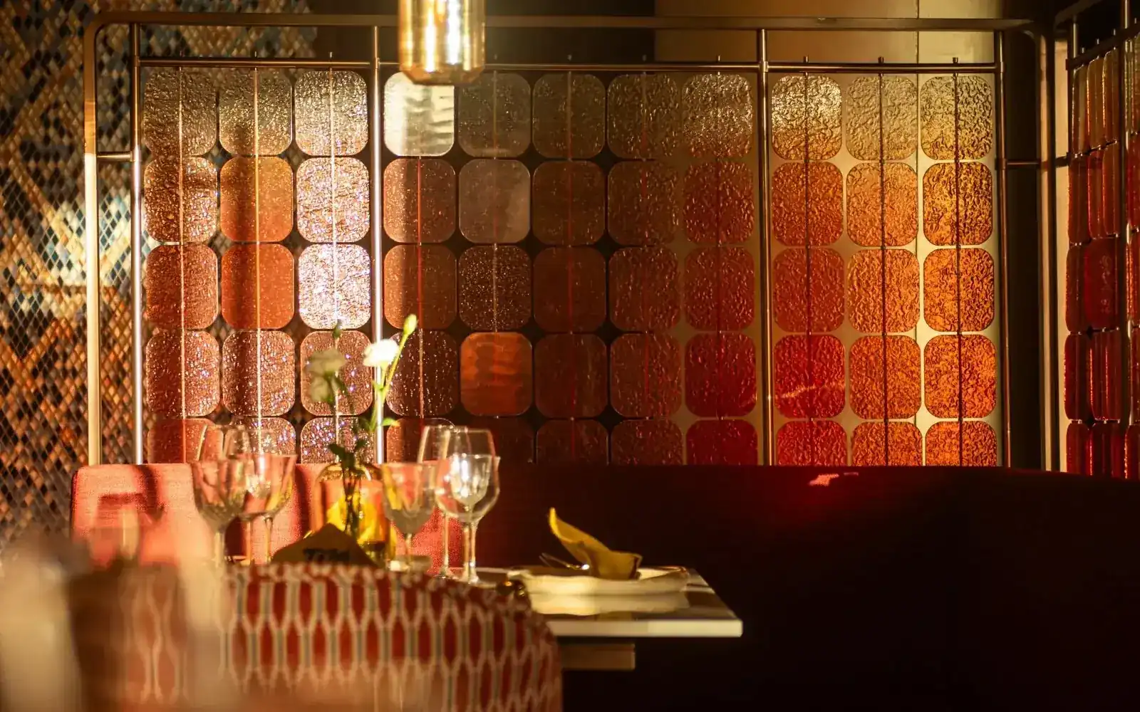 The amber glass screen glowing behind a set table at Thai Thai