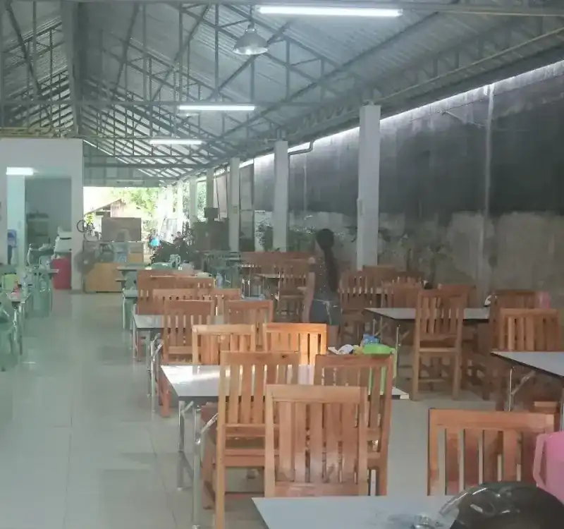 The covered dining hall with rows of wooden tables and chairs