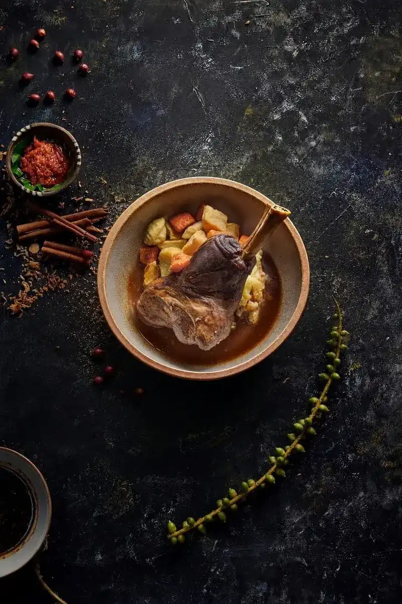 Braised lamb shank in a bowl of spiced broth