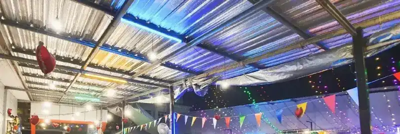 Coloured lights and bunting under the tin roof at night