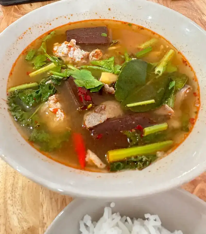 Pork blood soup, tom yum style, with minced pork, greens and chilli