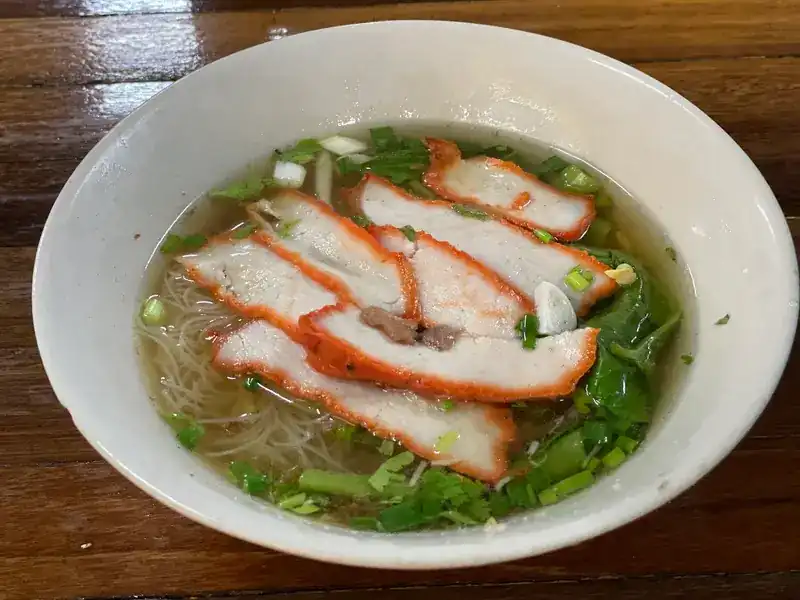 Red pork noodle soup with greens