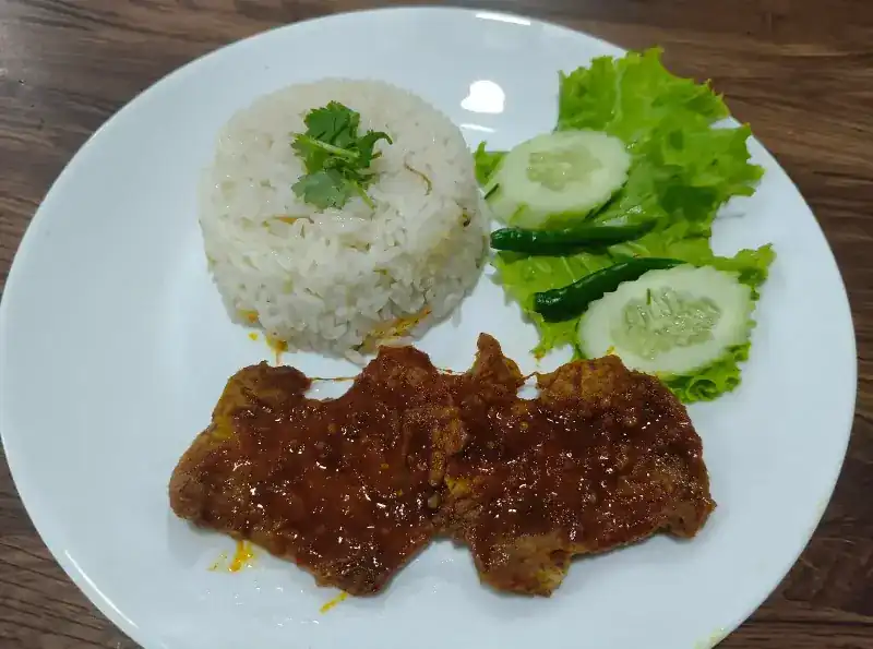 Rice, cucumber and chilli, with a fried cutlet in glossy red sauce