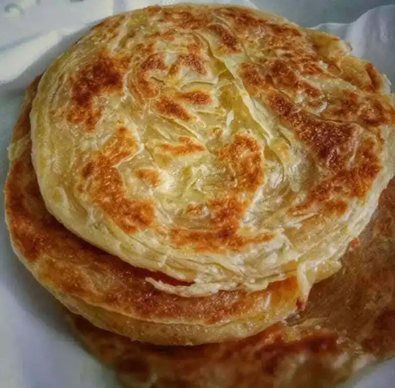 A stack of flaky, pan-fried plain roti