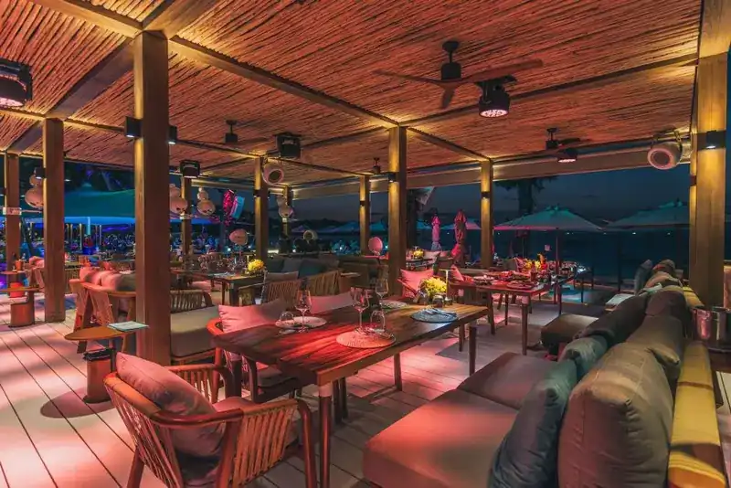 The covered dining deck lit in warm red at night