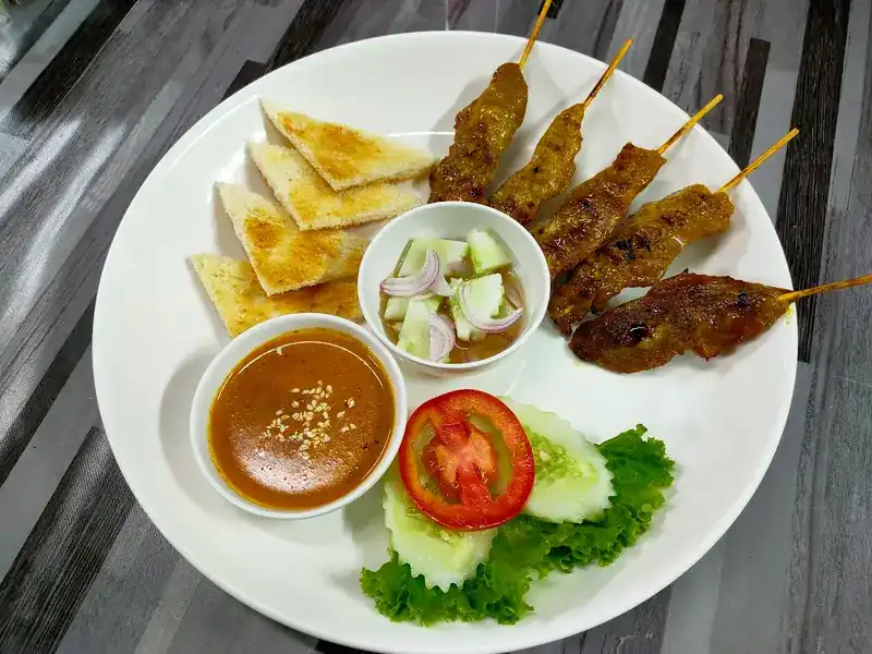Satay skewers with peanut sauce, toast and cucumber relish