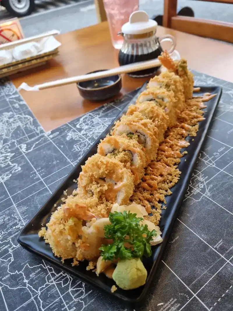 Crunchy tempura shrimp roll on a long black plate