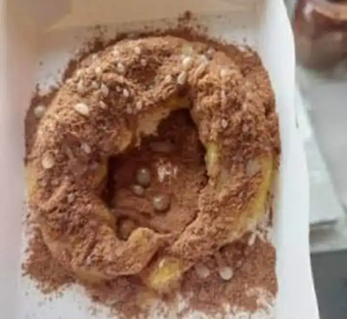 A roti dusted with chocolate powder in a takeaway box