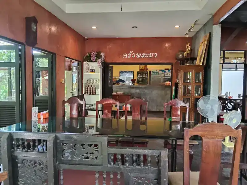 The red room, carved wooden screens in front and the counter at the back under the name ครัวพระยา