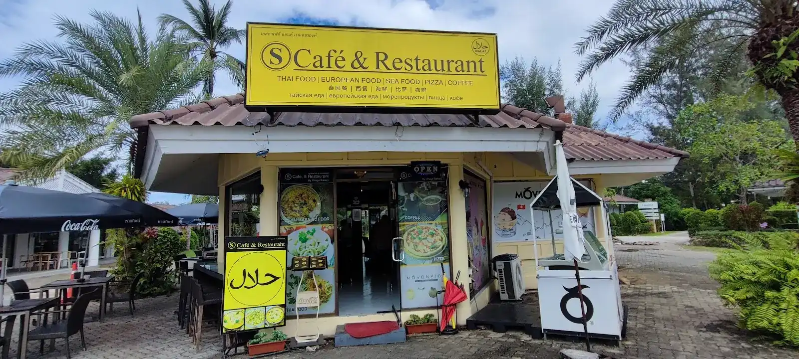 The shopfront of S Café & Restaurant under its yellow sign, with a halal board by the door and tables outside