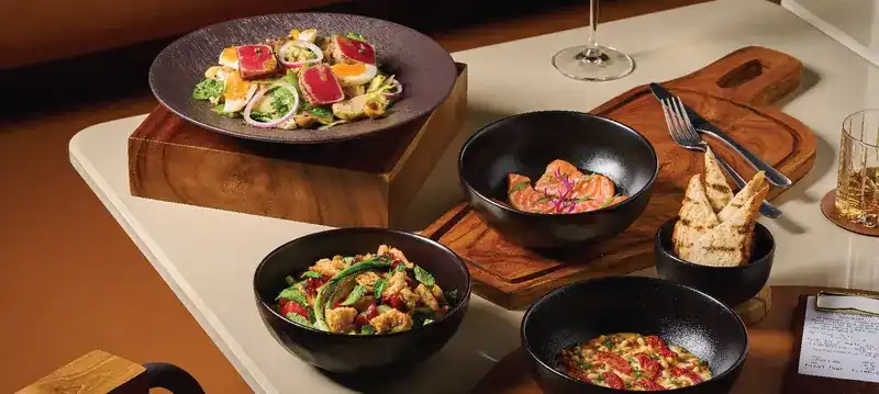 Salads, cured salmon and toasted bread laid out to share