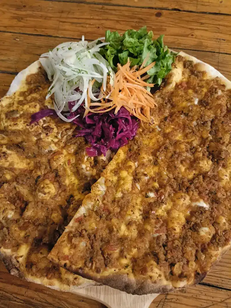 Thin flatbread with a minced meat topping, with onion, carrot and red cabbage
