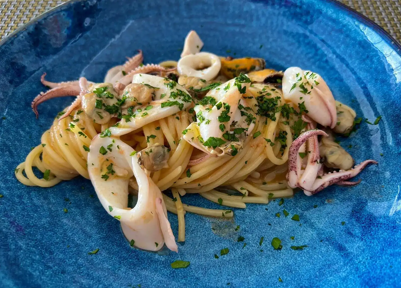 Spaghetti with squid and mussels on a cobalt-blue plate